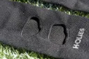 Nahaufnahme der eingefassten Öffnungen und des HOLIES-Schriftzugs einer schwarzen Cut Sleeve.