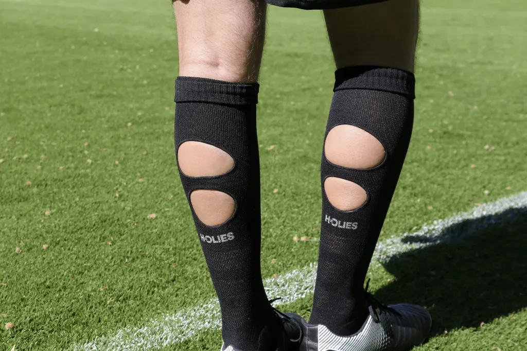 Rückansicht der schwarzen HOLIES Socken mit zwei Wadenöffnungen und HOLIES-Schriftzug.